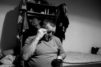 Erns Moravitz in dem Schlaf- und Wohnzimmer, dass er sich mit zwei weitern Arbeitern teilt. Er telefoniert mit seiner Frau, die in Polen in einem Krankenhaus als Krankenschwester arbeitet. -  Wesel. Deutschland. Oktober 2016